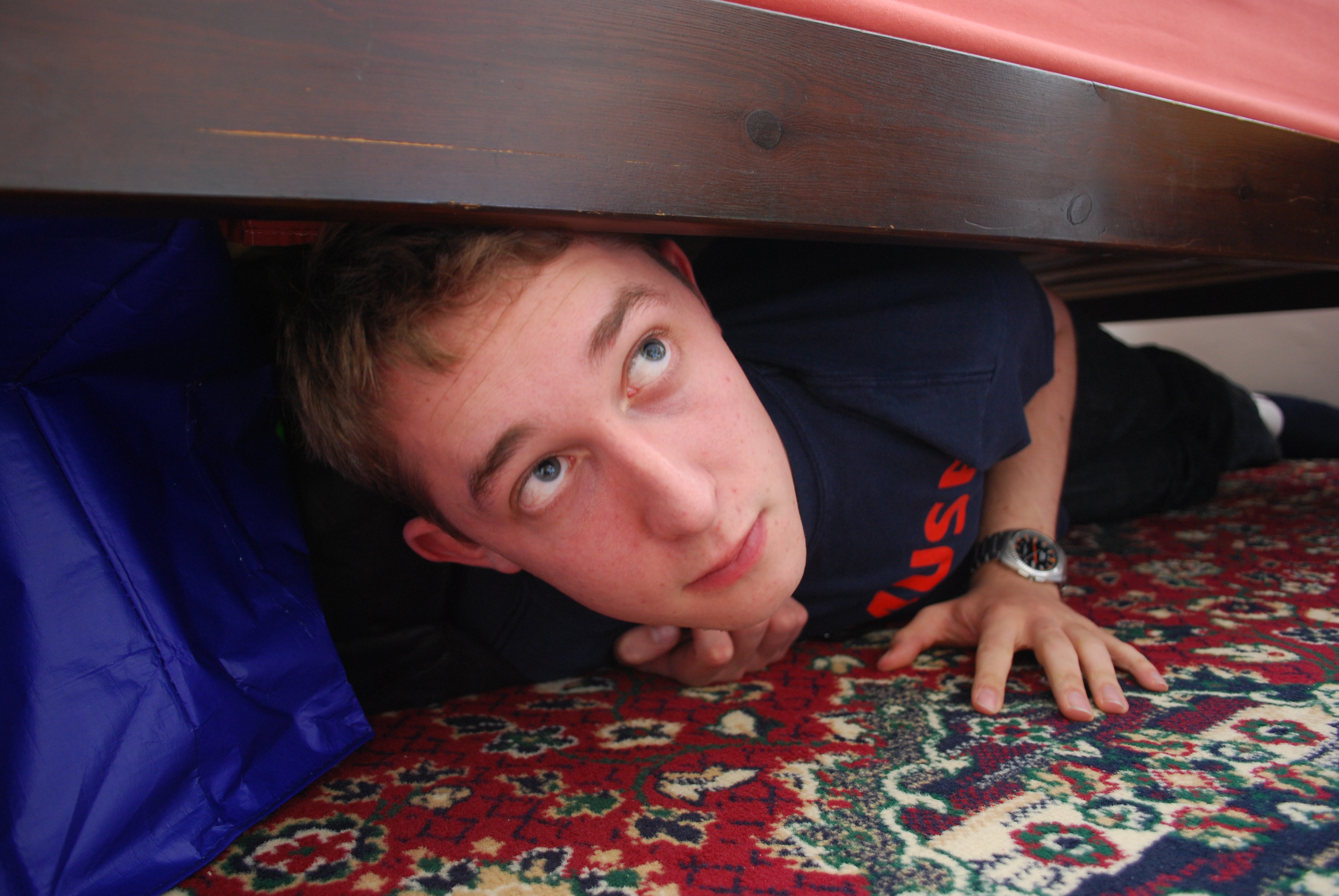 Муж прячет телефон. Мужчина спрятался под кроватью. Спрятался под кровать. Мужчина прячется. Муж под кроватью.